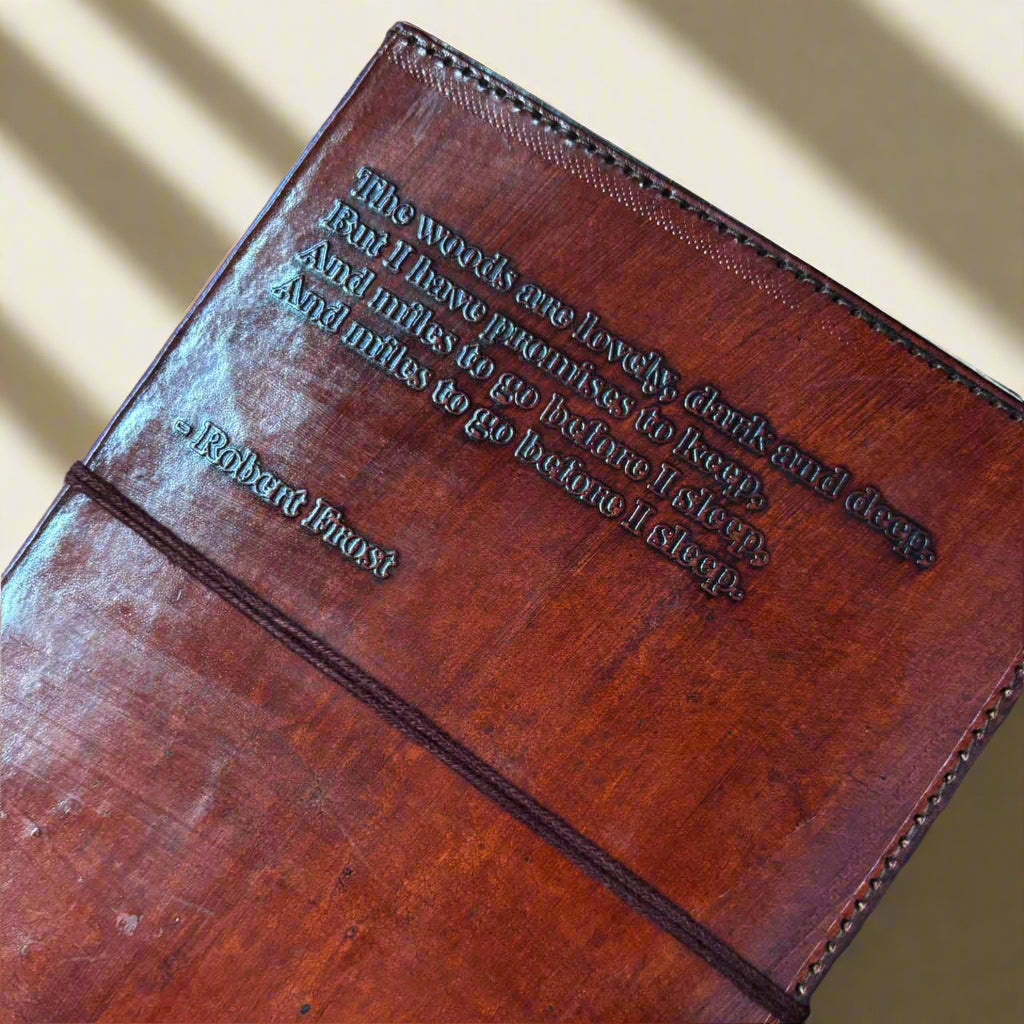 Brown leather-bound book with embossed text on a beige background
