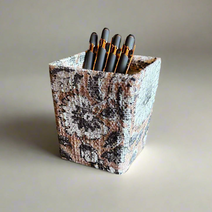 Marble-patterned pencil holder with pencils on a neutral background