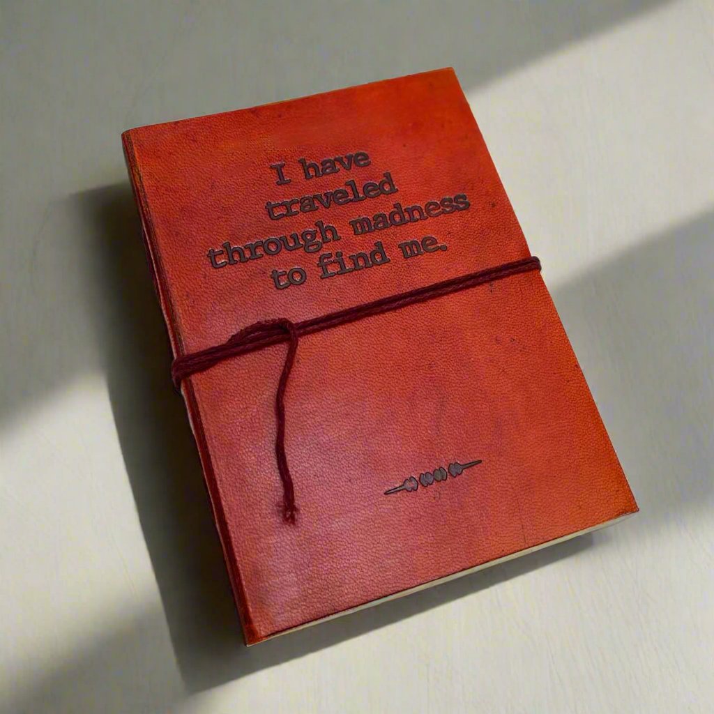 Front cover of the Traveled Through Madness Quote Leather Journal showing debossed I Have Traveled Through Madness To Find Me quote