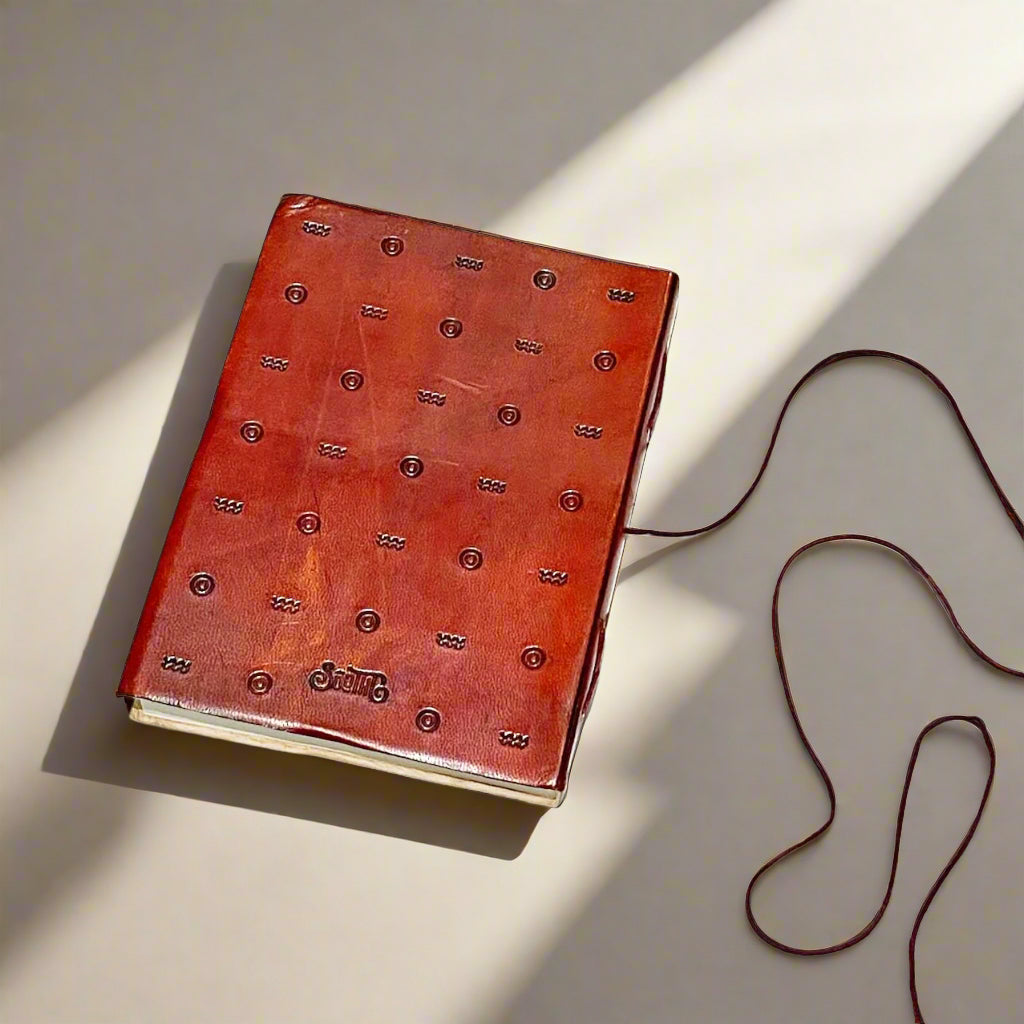 A handcrafted red leather journal with an embossed inspirational quote - dedicated space to process your thoughts, cultivate positivity, and reinforce