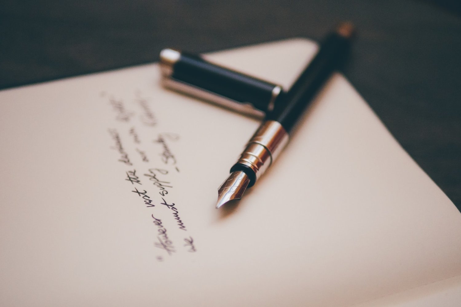 Calligraphy pen and practice sheet with elegant lettering — representing the creative and relaxing process of learning calligraphy as a rewarding hobby.