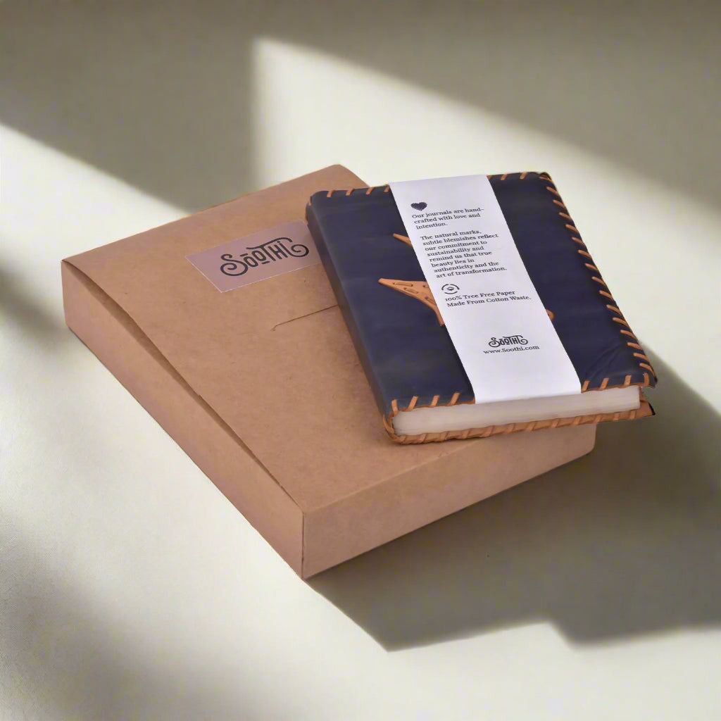 Notebook with a brown cover and white interior, placed on a cardboard box with a visible brand logo.
