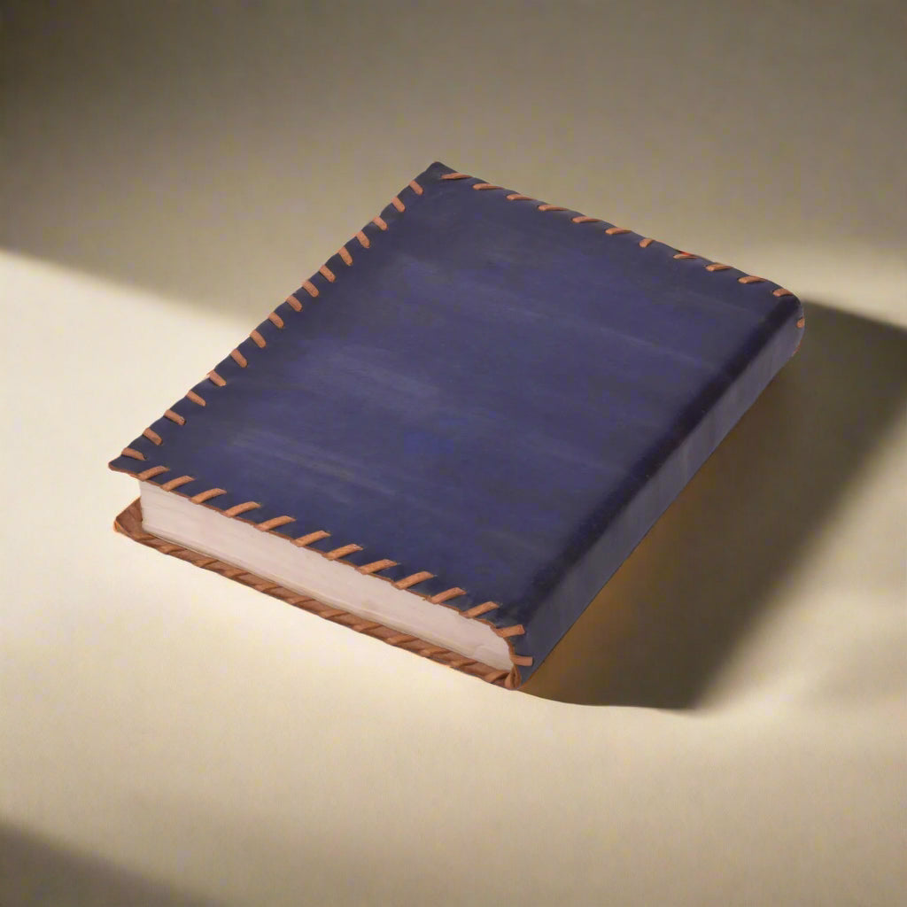 Blue leather notebook with brown stitching on a white background