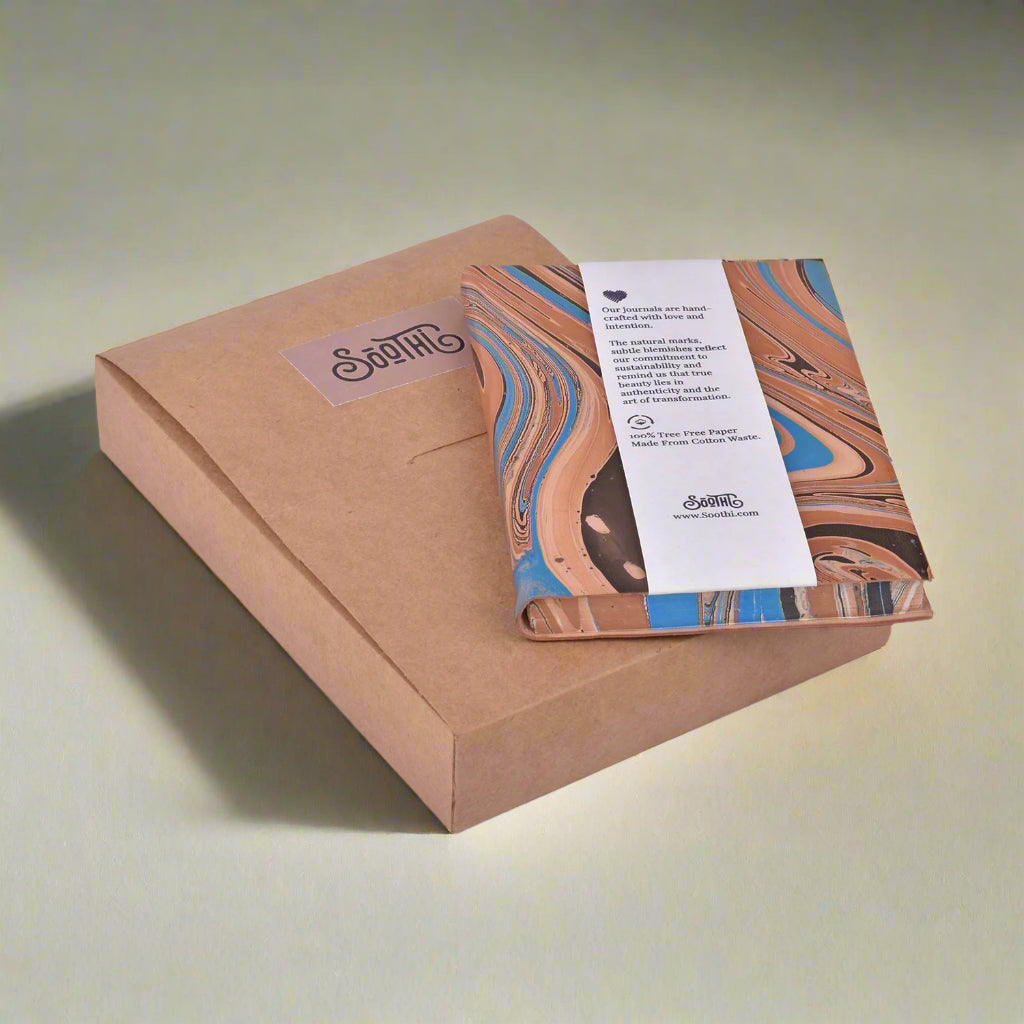 Kraft paper box with a marbled design notebook and a label on a white background