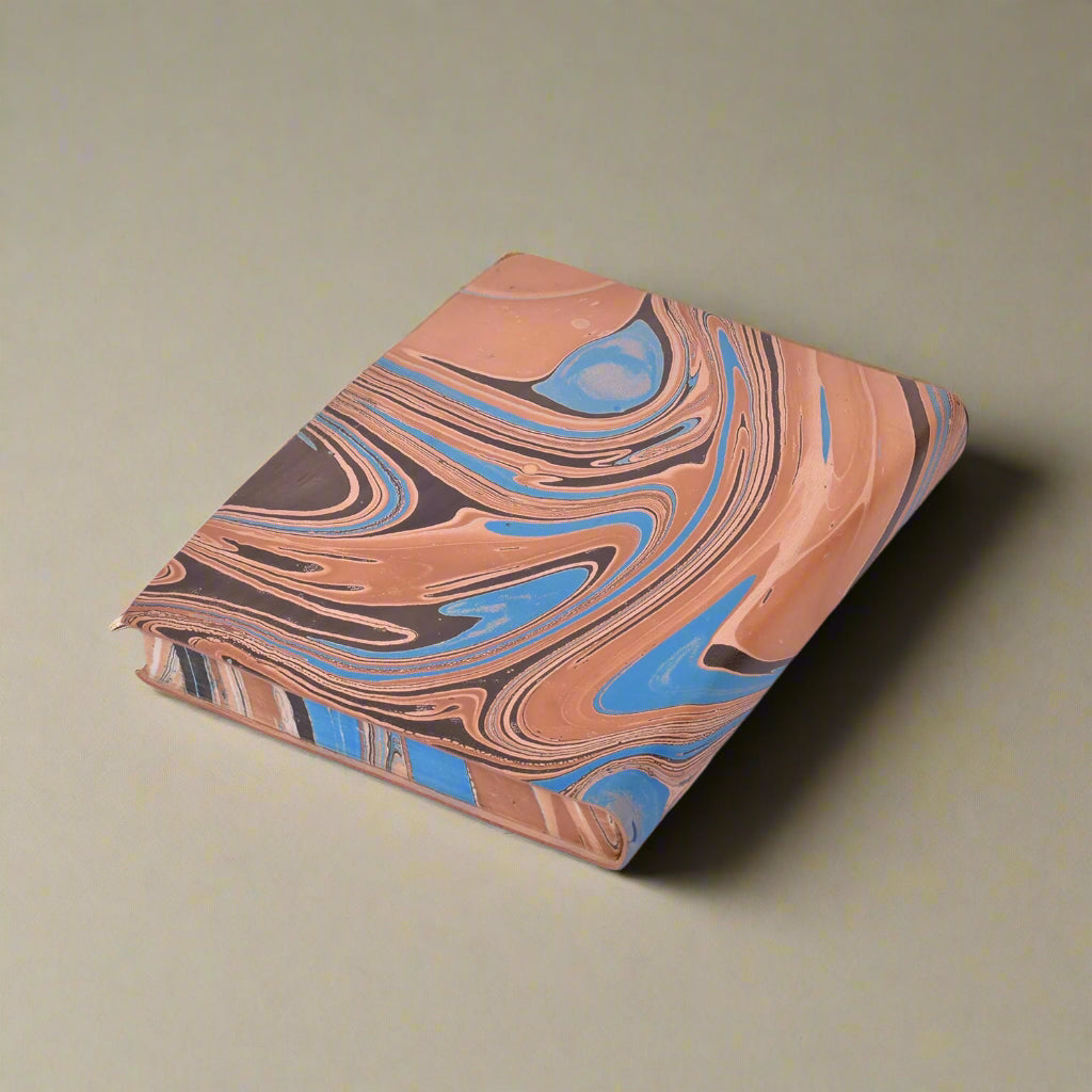 Marbled notebook with brown, blue, and black pattern on a white background