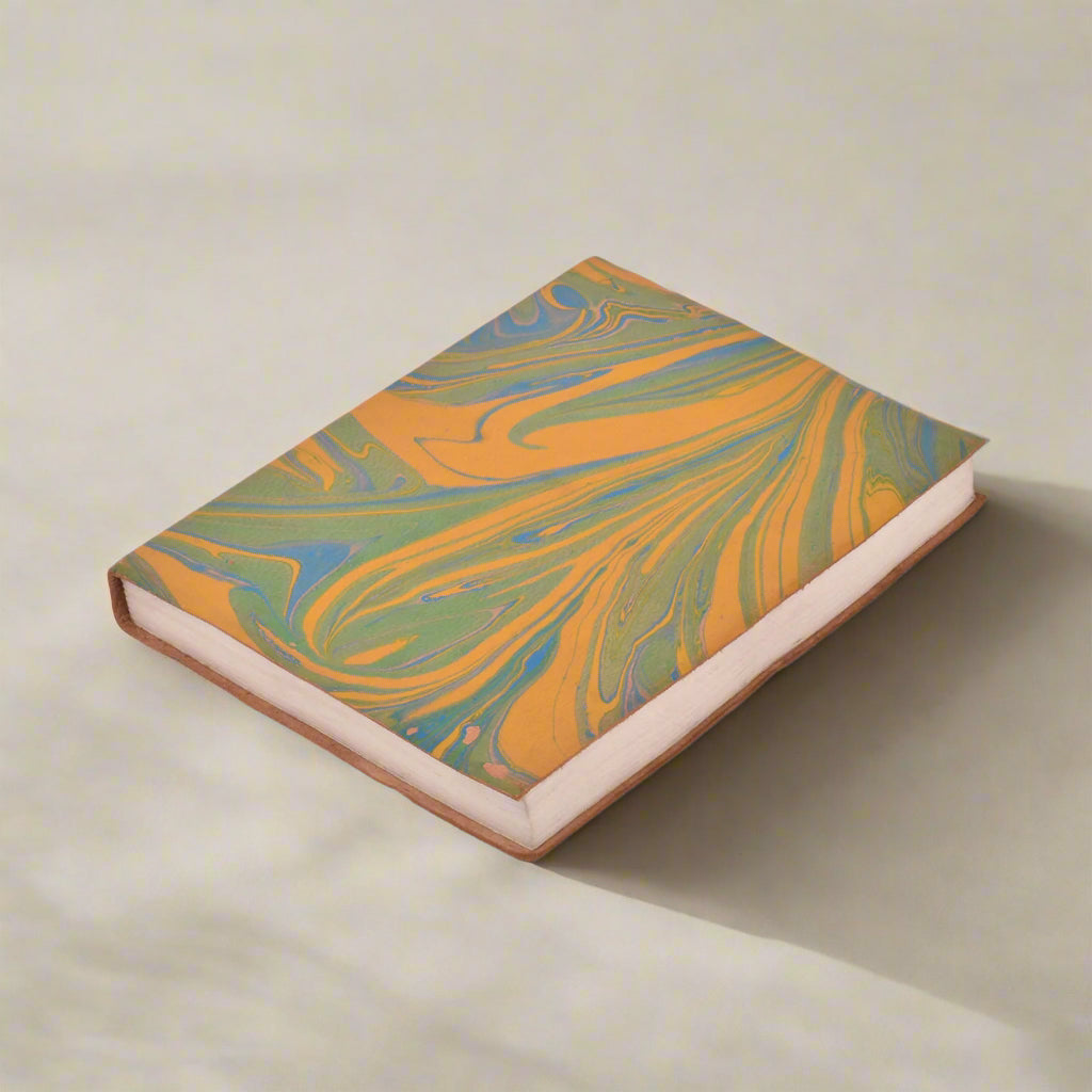 Marbled notebook with orange and green design on a white background