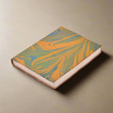 Marbled notebook with orange and green design on a white background