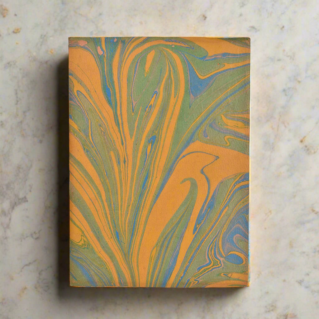 Notebook with marbled orange and green design on a white background