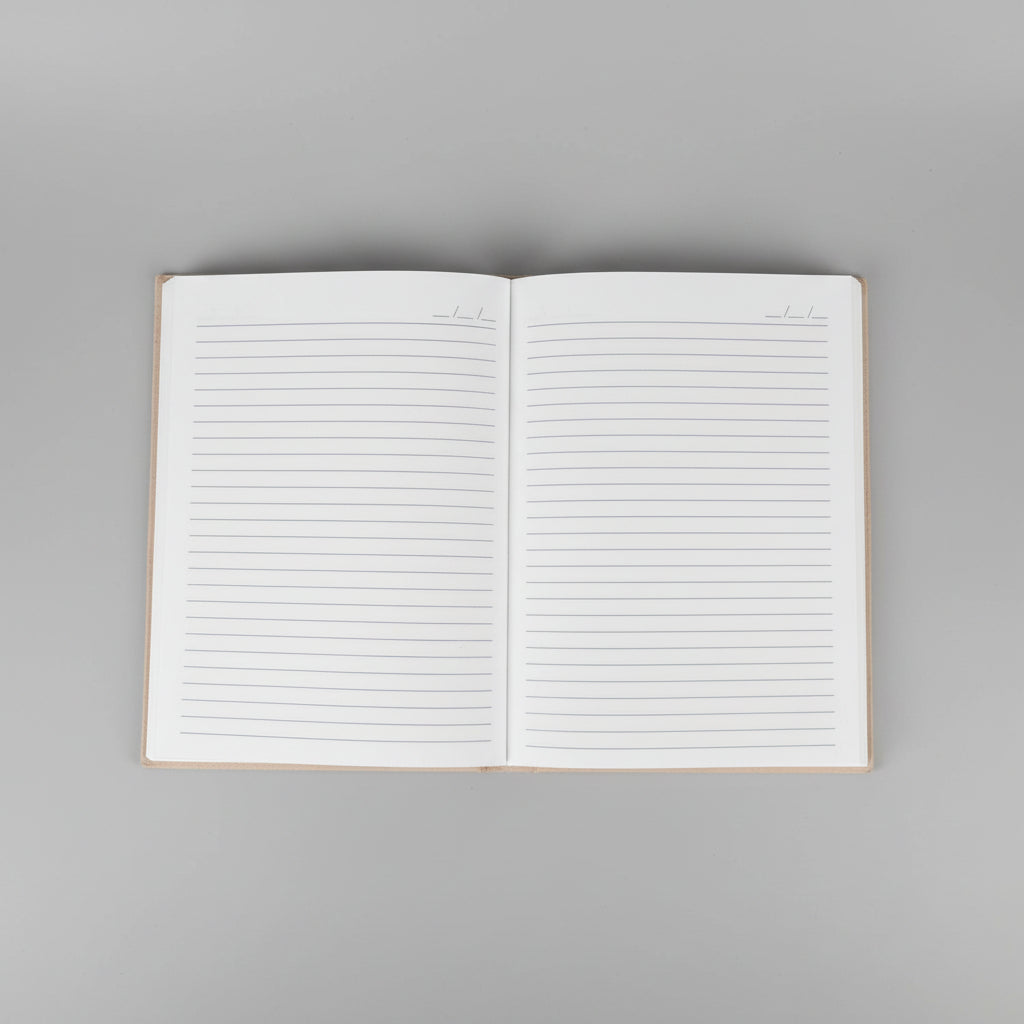8x6 open lined notebook or planner with blank lined pages, photographed from above on a warm brown surface.