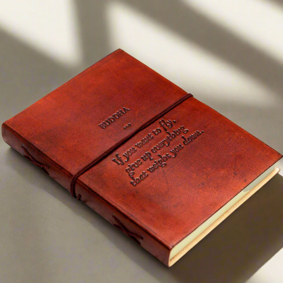 Brown leather notebook with text on a wooden surface