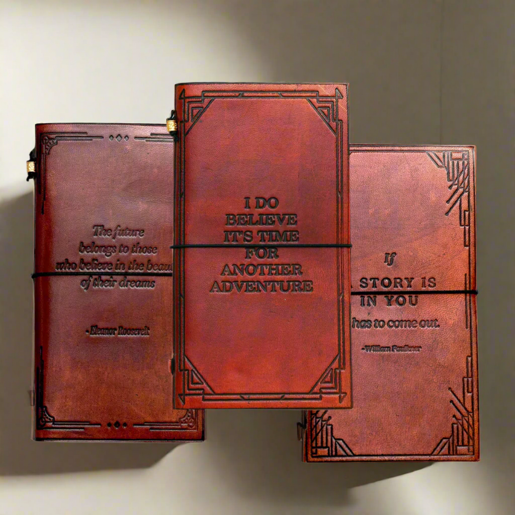 Three brown leather journals with embossed text on a white background