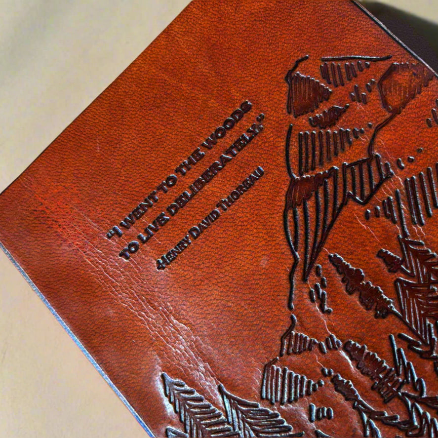 I Went to the Woods to Live Deliberately brown leather journal with a debossed quote and string-tie closure