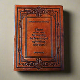 Decorative leather-bound book with a quote on a beige background