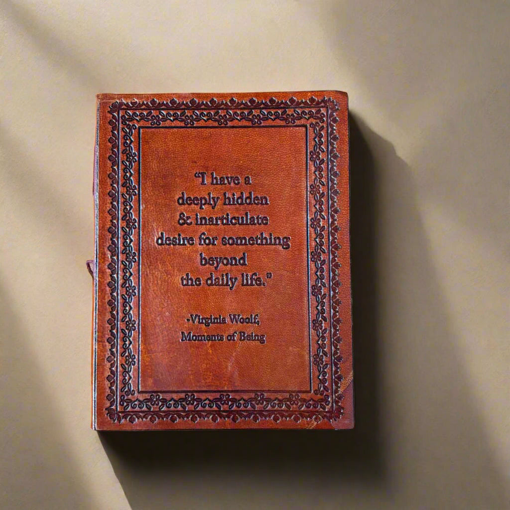 Brown leather-bound book with embossed text on a beige background