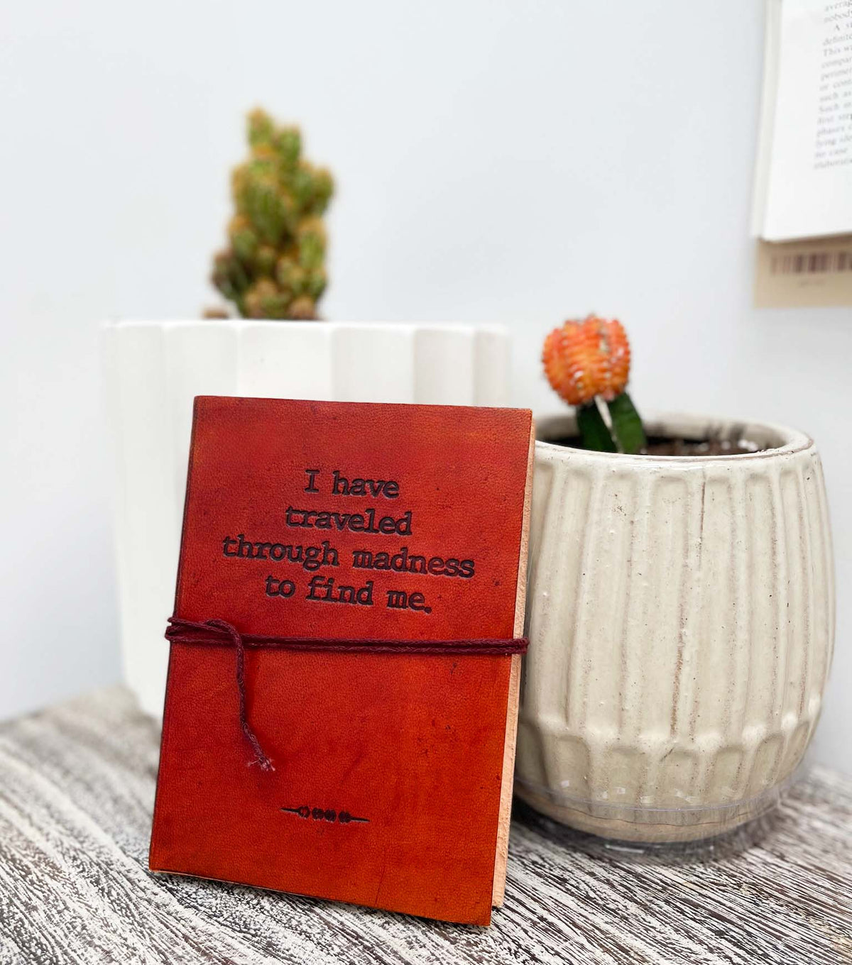 Different angle of the Traveled Through Madness Quote Leather Journal showing the cover and page edges