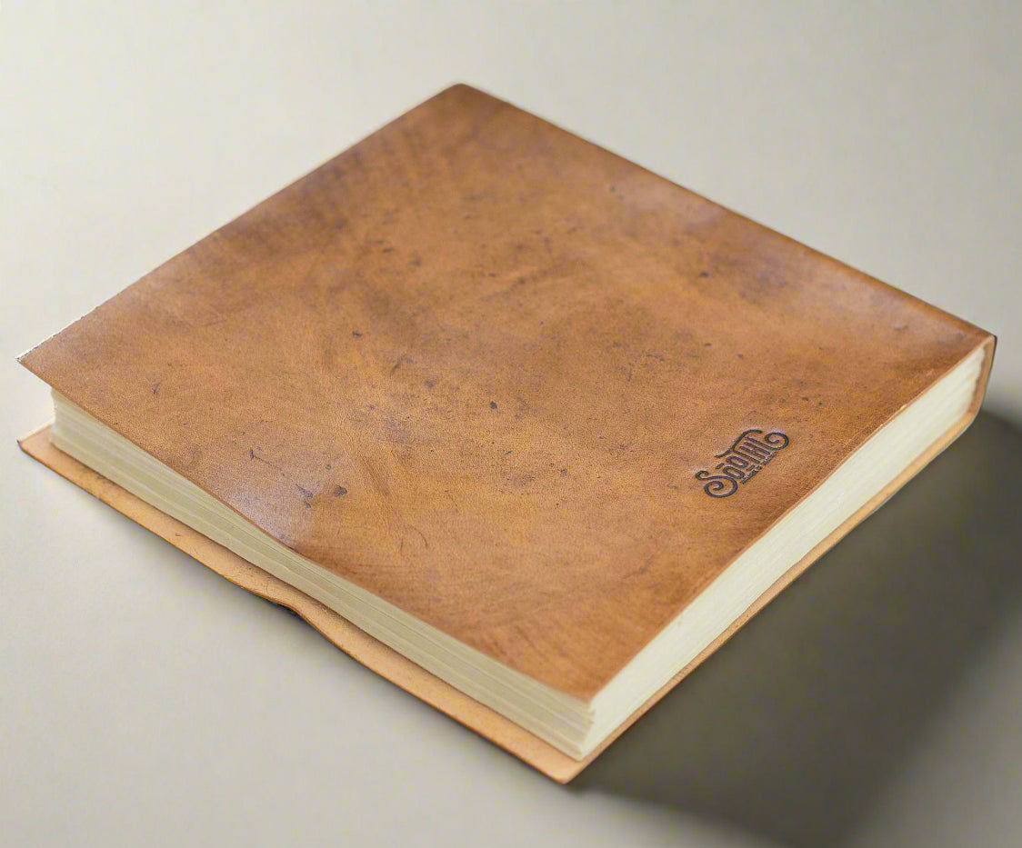 Moon Phases 7x7 leather journal held in hand for scale