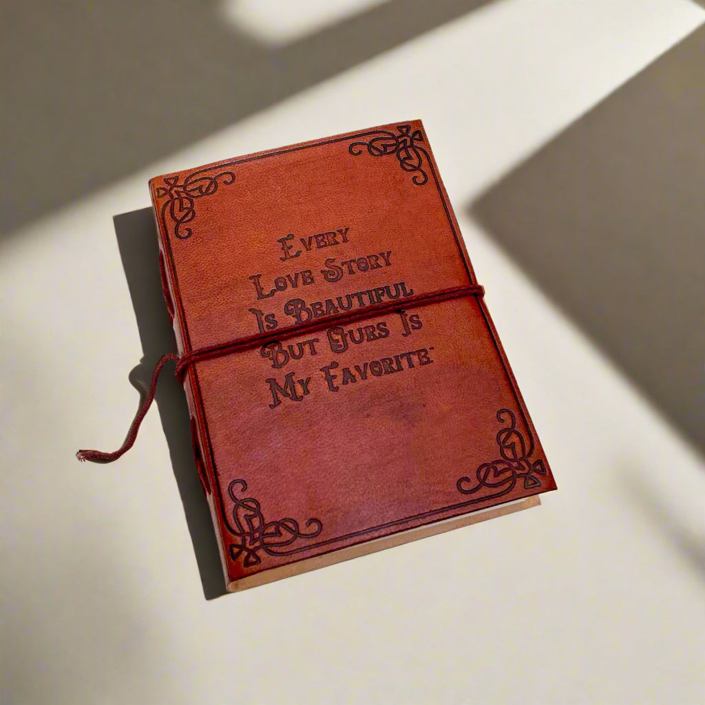 Close-up of embossed love quote on brown leather journal cover