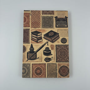 Close-up of the Grand Trunk Notebook cover showing ink pots and literary symbols