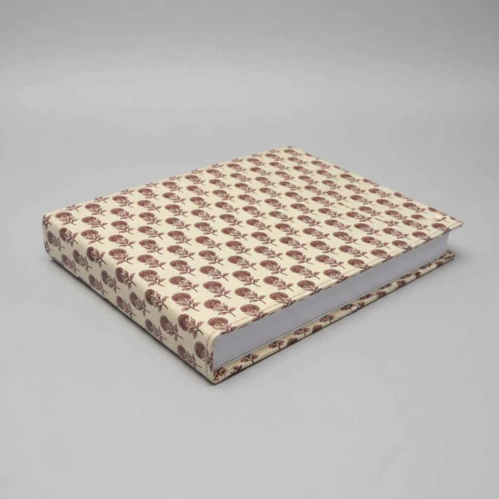 Book with floral pattern on beige cover against a gray background