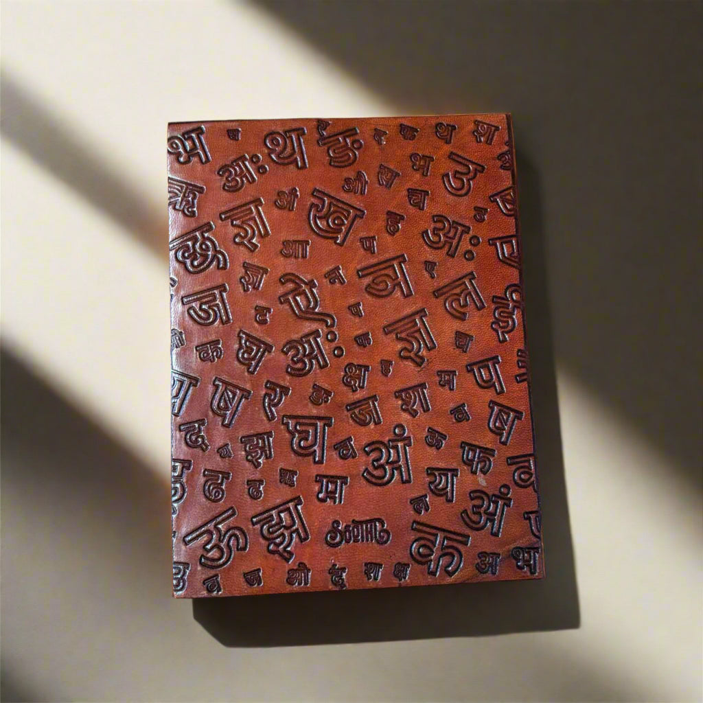 Close-up of debossed Quiet the Mind quote and surrounding symbolic motifs on leather