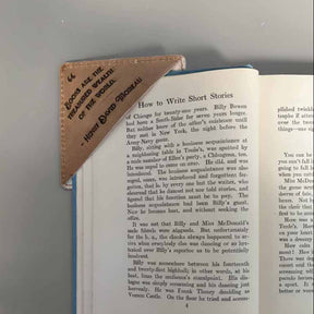 Open book with a leather-bound notebook on top, on a gray background