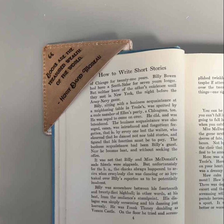 Open book with a leather-bound notebook on top, on a gray background