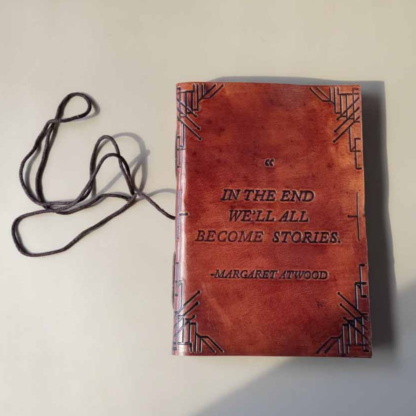 We All Become Stories 5x7 brown leather journal with embossed quote cover