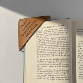 Open book with a leather bookmark on a gray surface