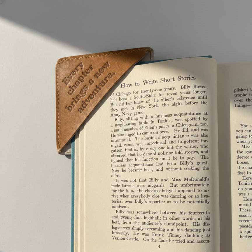 Open book with a leather bookmark on a gray surface